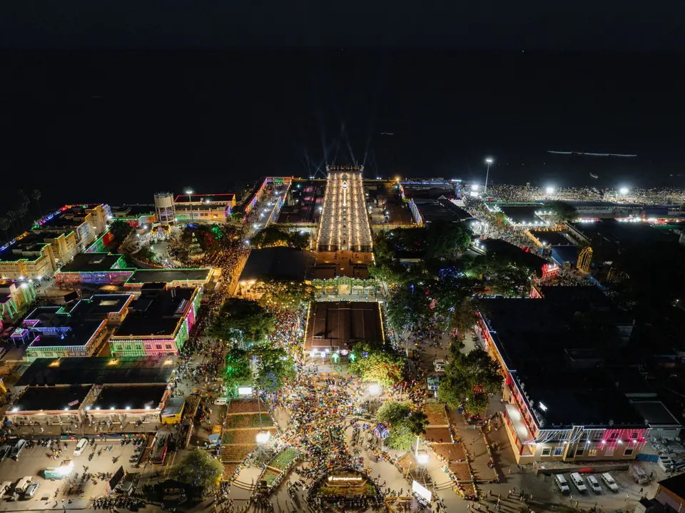 Thiruchendur temple lit at night during a festival, seen from the air